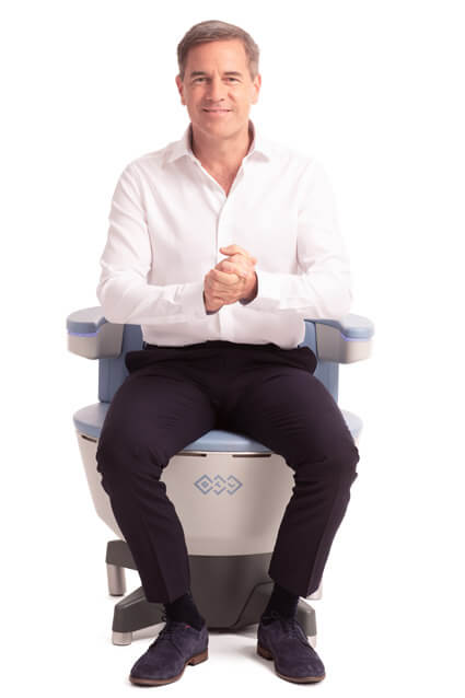 Man sitting on emsella chair smiling