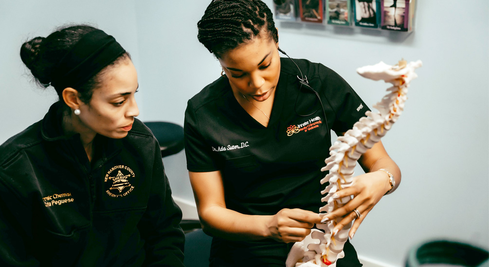 Dr. Ada pointing to spine model with patient