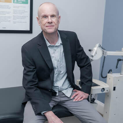 Dr. Richie sitting on adjusting table