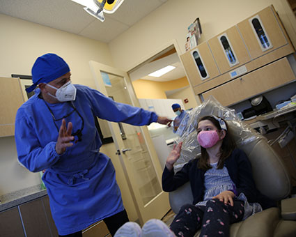 Staff waving to girl in chair