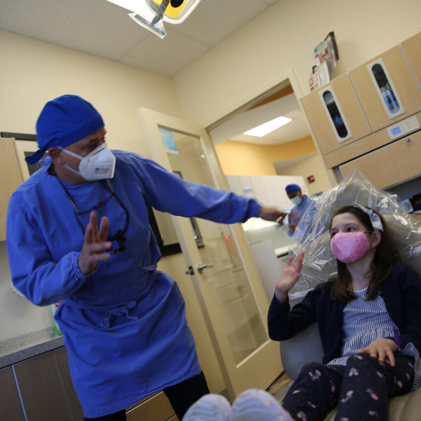 doctor waving hello to child patient