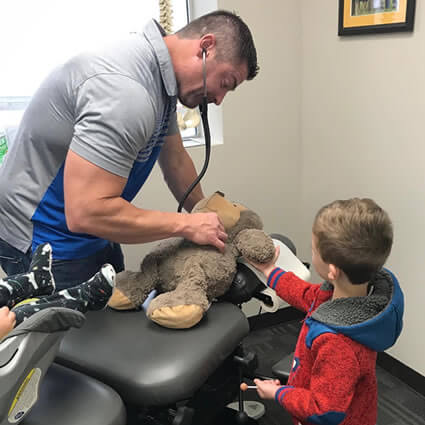 Dr. Adam playing with boy and his teddy bear