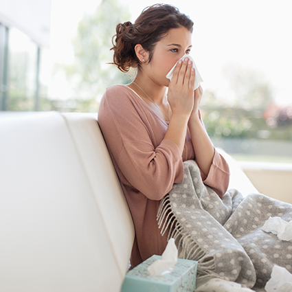 woman with a cold resting on a couch