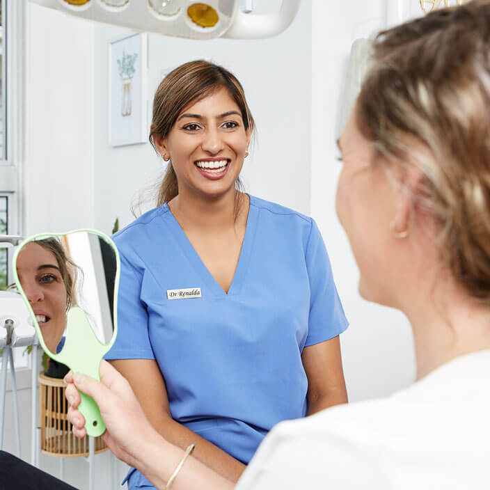 Dentist with patient looking in mirror
