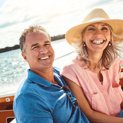 smiling couple on a boat during summer