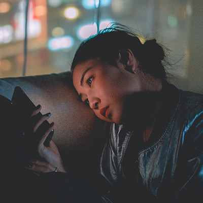 woman looking at her phone at night