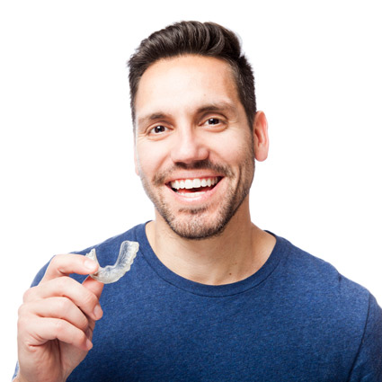 man smiling holding  clear aligners