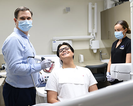 Dentist with mask by patient