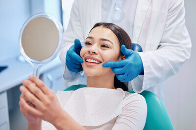 women-smiling-at-mirror-beautiful-white-teeth.h