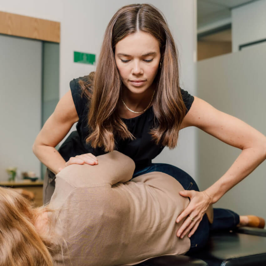 chiropractor adjusting patients back
