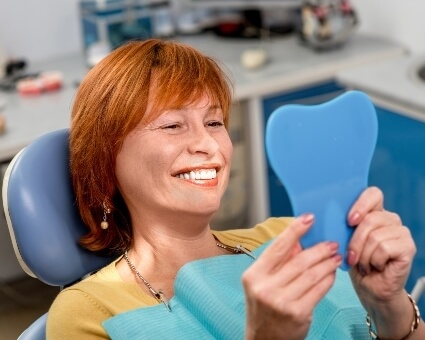 Lady on dental chair looking at self in mirror