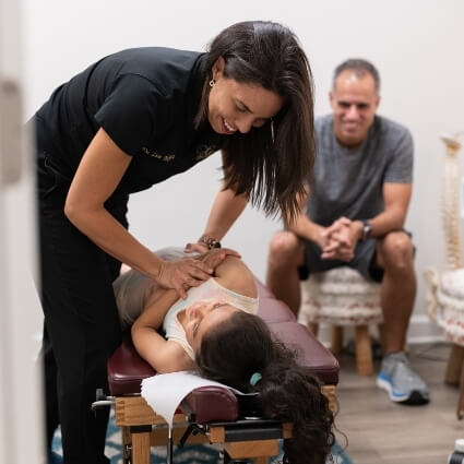 Dr Liz adjusting child patient with family watching