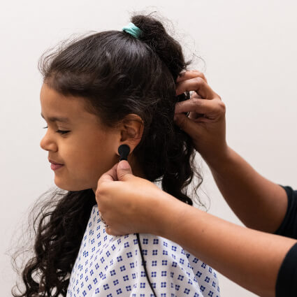 device on child patient's ear lobe