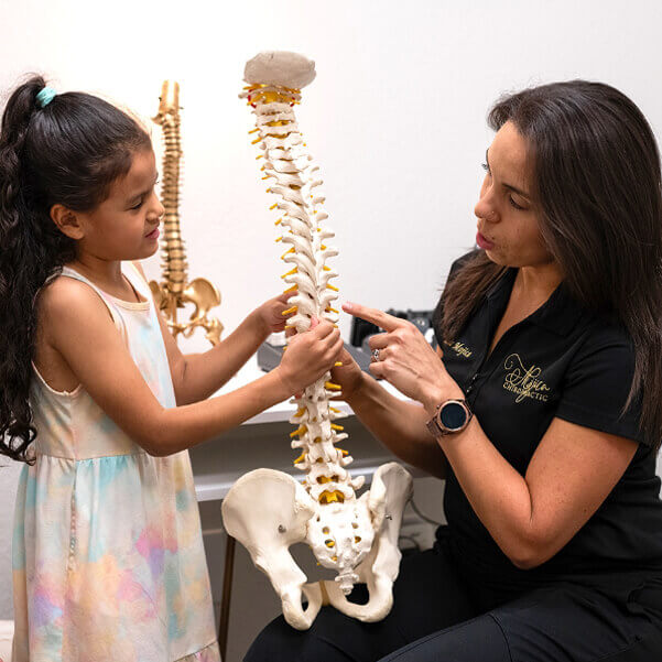 Winter Springs chiropractor Dr Liz showing spine model to child