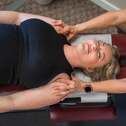 smiling person getting shoulders adjusted