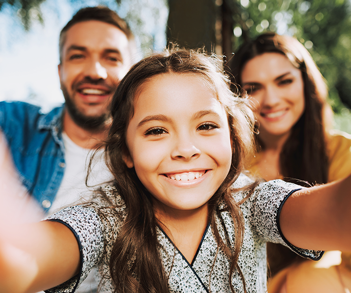 child taking selfie with parents