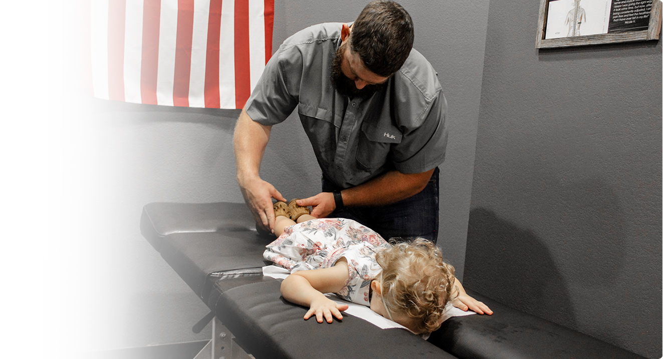 Chiropractor adjusting child's legs