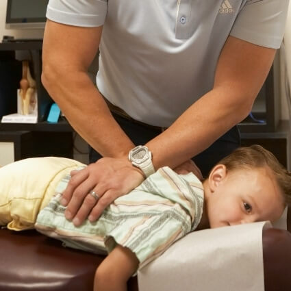 Chiropractor adjusting a pediatric patient