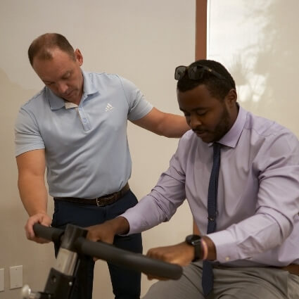 Chiropractor assisting patient with equipment
