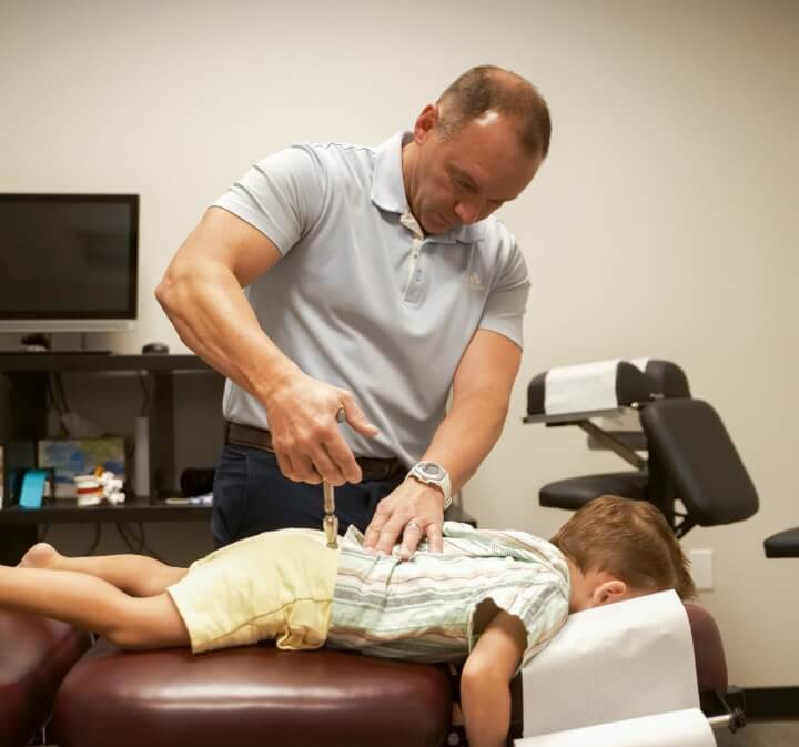 Mesa pediatric patient getting adjusted with chiropractic tool