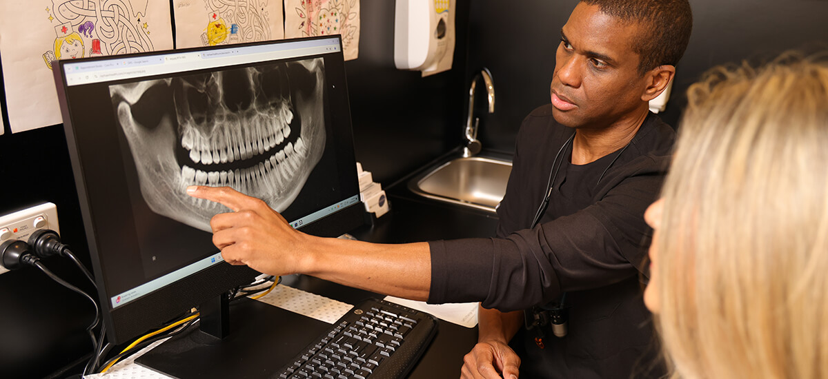 PresiDental Smiles Dr Wren looking at xrays with patient