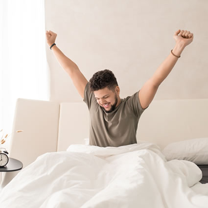 young man stretching happy waking from bed
