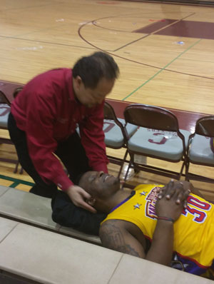 Dr. Mariano adjusting a basketball player