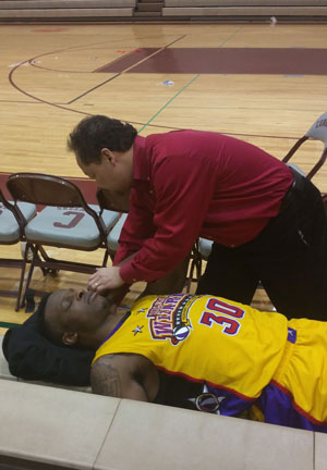 Dr. Mariano adjusting a basketball player