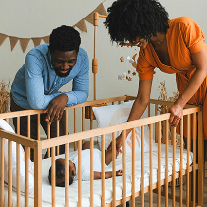 parents looking at baby in crib