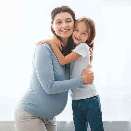Mom and young daughter hugging