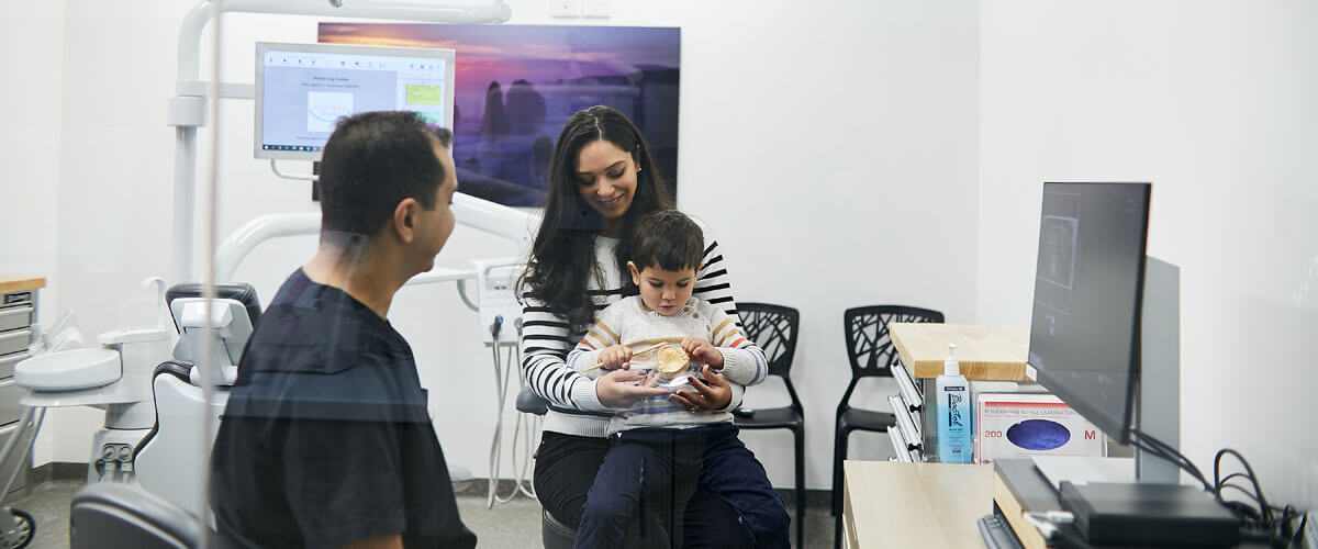 Dr Mina with mom and child in treatment room