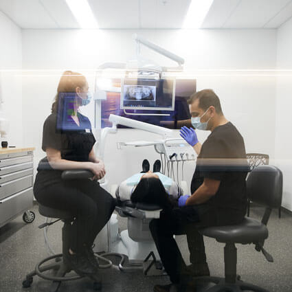 patient in treatment chair with xrays above
