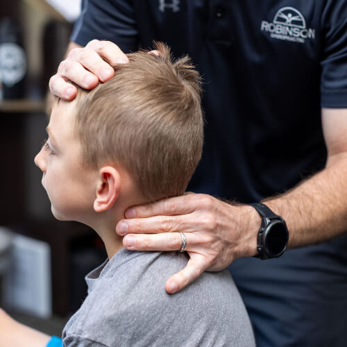 Chiropractor adjusting child's neck