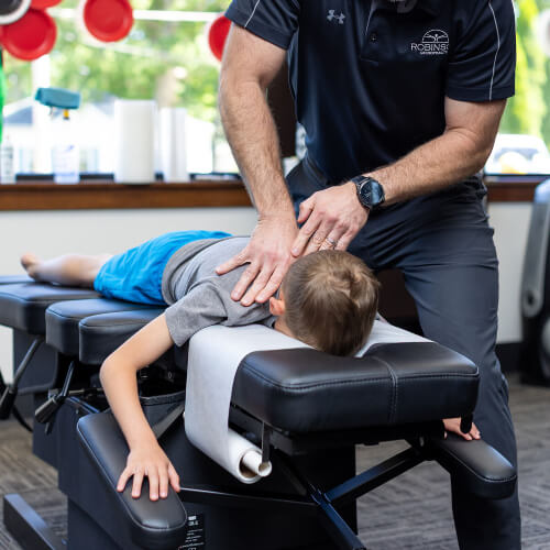 Boy receiving neck adjustment