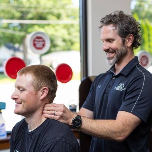 Male patient receiving a chiropractic neck adjustment
