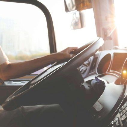 A driver navigating the city streets during a sunny day, focusing on the road.