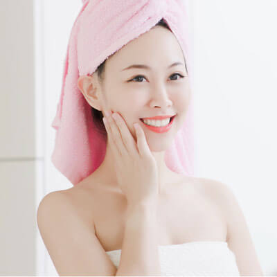 young woman smiling wearing a towel