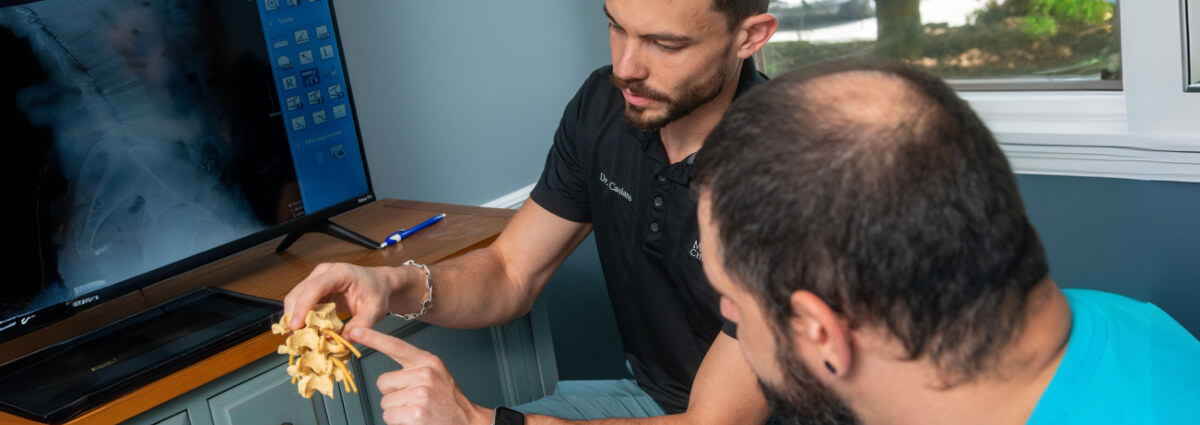 Dr Juan pointing at a spine model