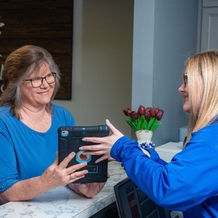patient at our front desk looking at an ipad