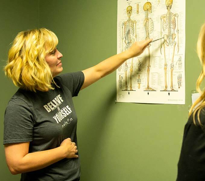 Dr. Traci pointing to spine picture on wall