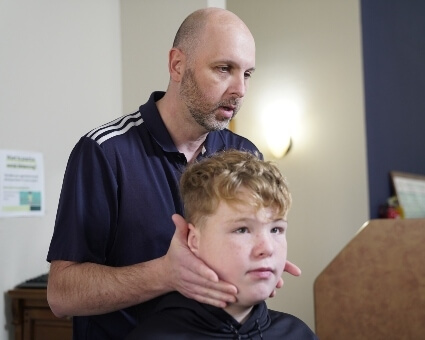 Pediatric Chiropractic Chiropractor adjusting boy's neck