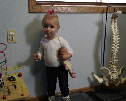 Pediatric Chiropractic Little girl holding a baby doll