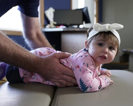 Pediatric Chiropractic Chiropractor adjusting young girl's upper-back