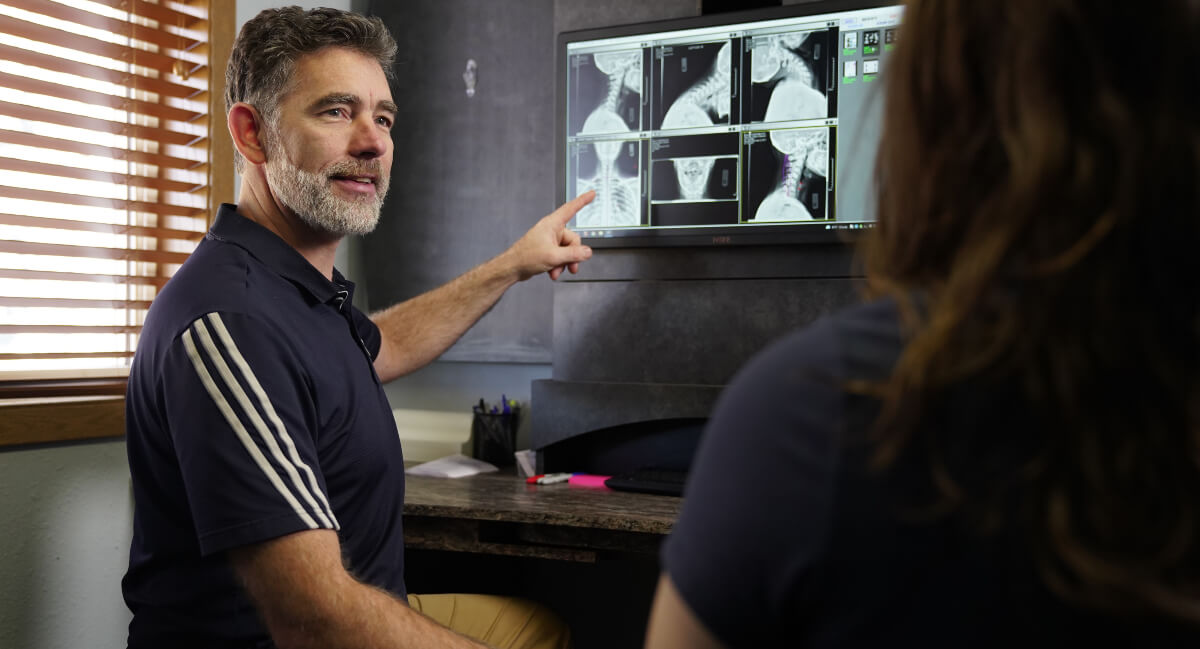 Portage chiropractor discussing x-ray results with practice member