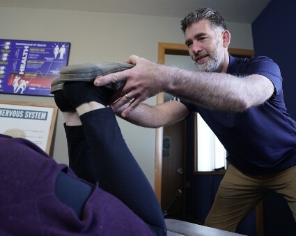 Chiropractor stretching patient's legs