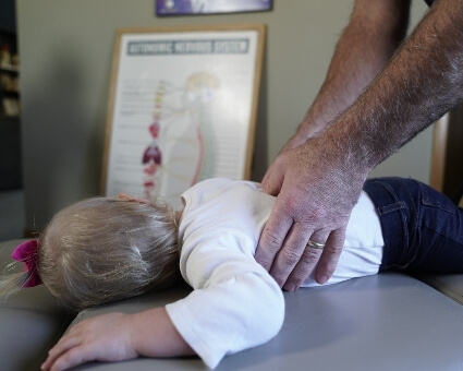 Pediatric Chiropractic Little girl receiving a back adjustment