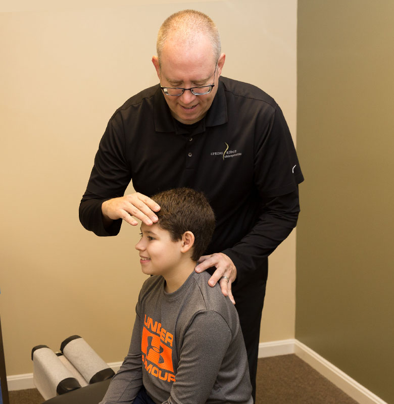 Dr. Chris adjusting young boy
