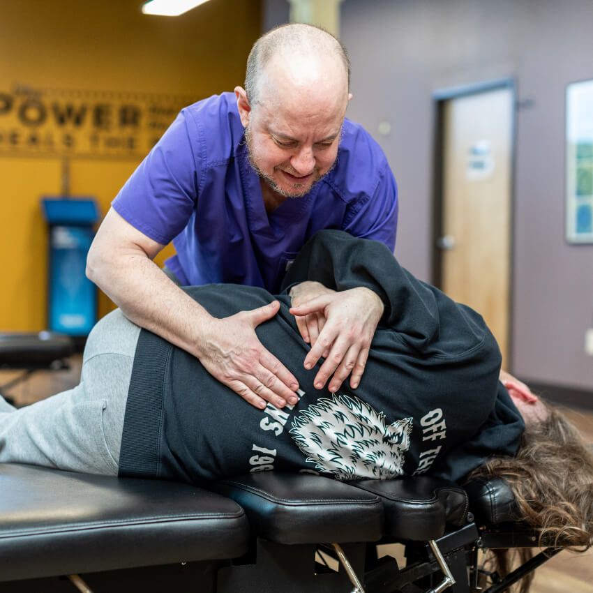 Portland chiropractor adjusting patients back