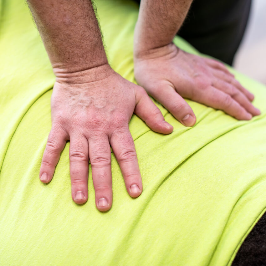 chiropractor with hands on a patients back
