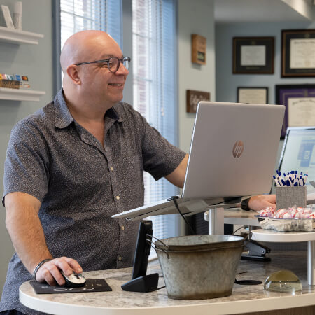 Male staff welcoming patient to About Life Chiropractic